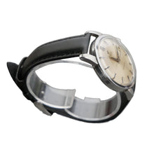 Load image into Gallery viewer, Vintage watch with black strap and beige dial on a gray background