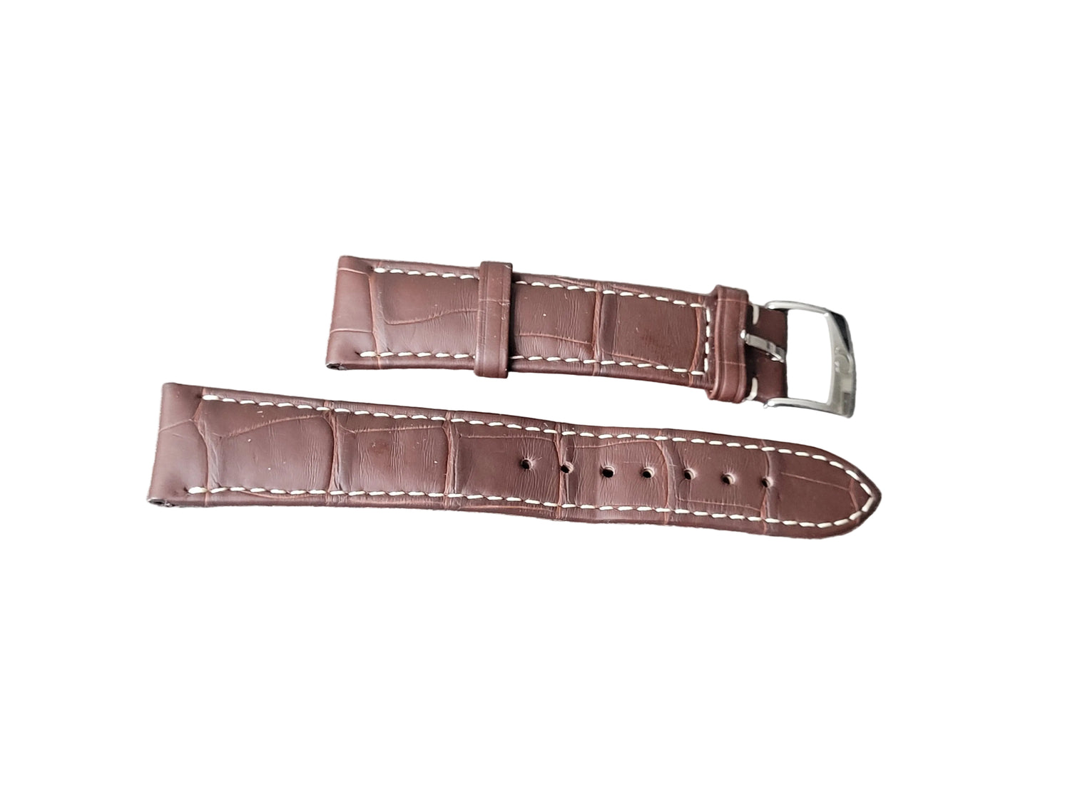 Brown leather watch strap with white stitching on a gray surface
