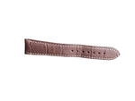 Brown leather watch strap with white stitching on a gray surface