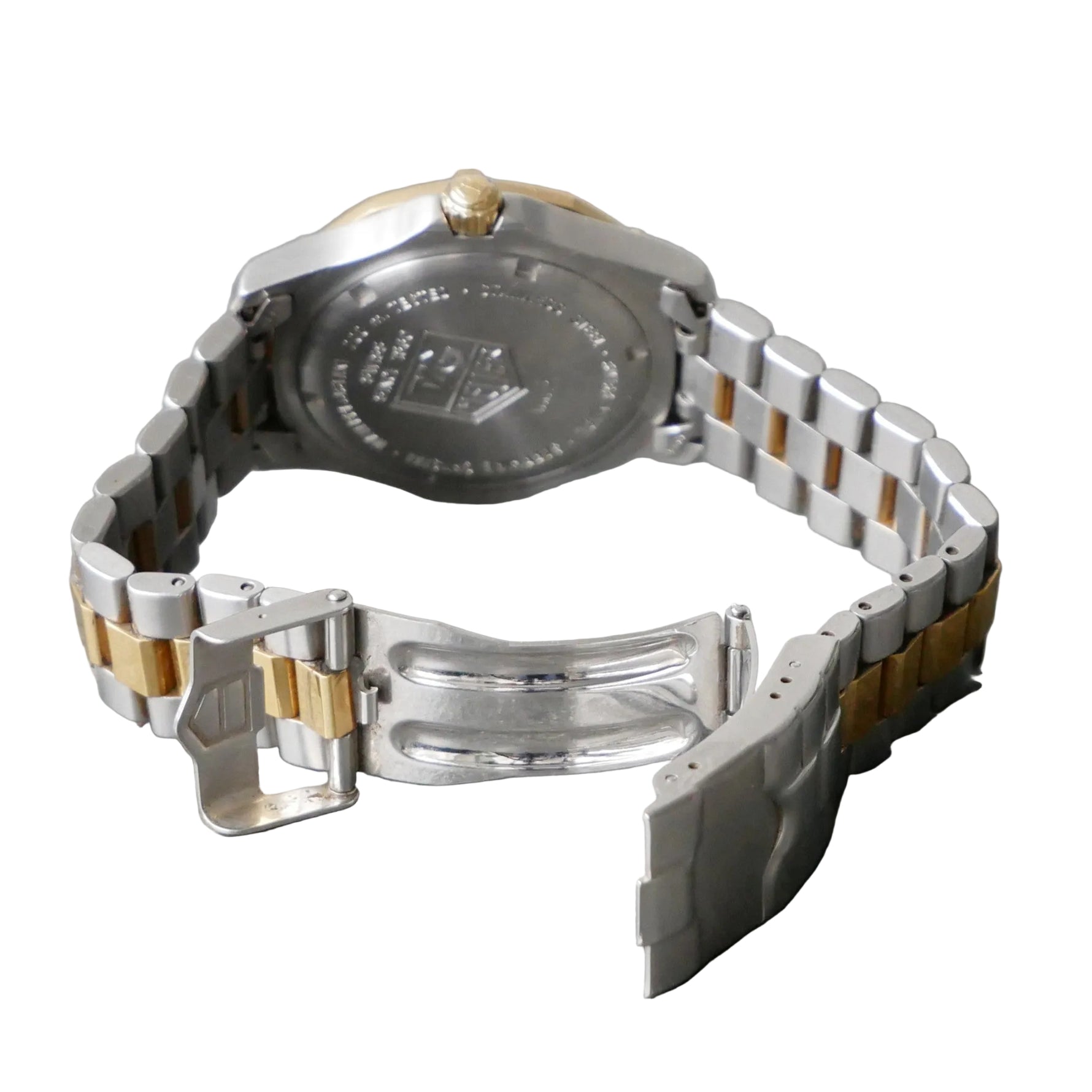 Silver and gold watch on a gray surface