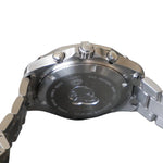 Close-up of a silver watch with brand logo on a gray background