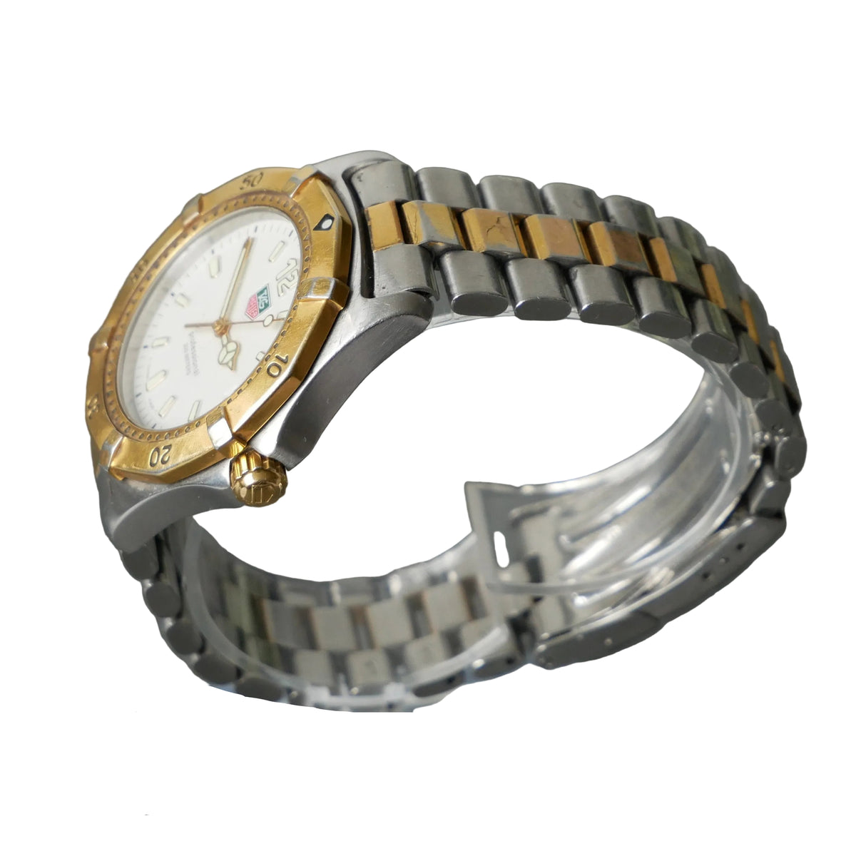 Silver and gold watch on a stand with a gray background