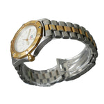 Silver and gold watch on a stand with a gray background