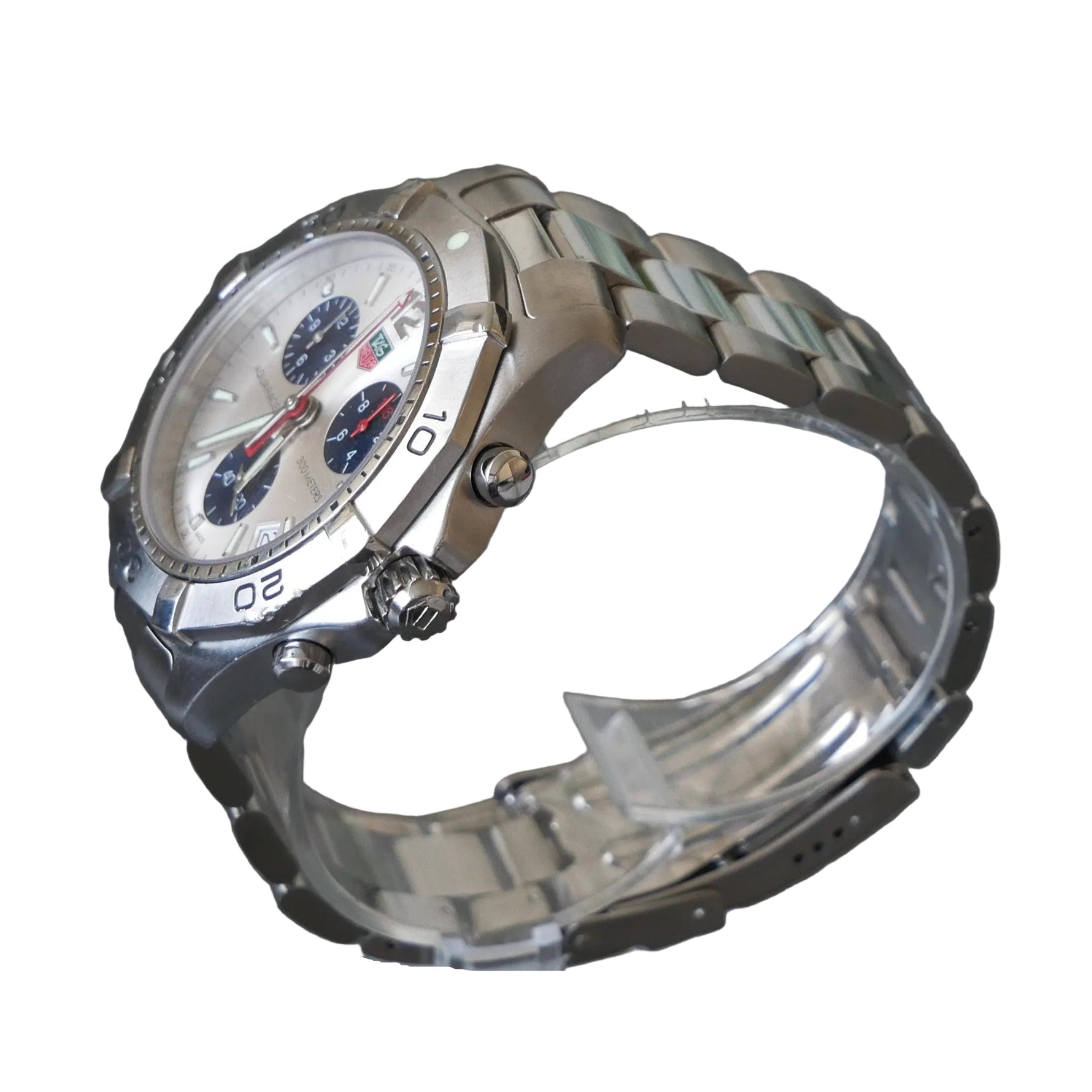 Silver wristwatch on a clear stand against a dark background