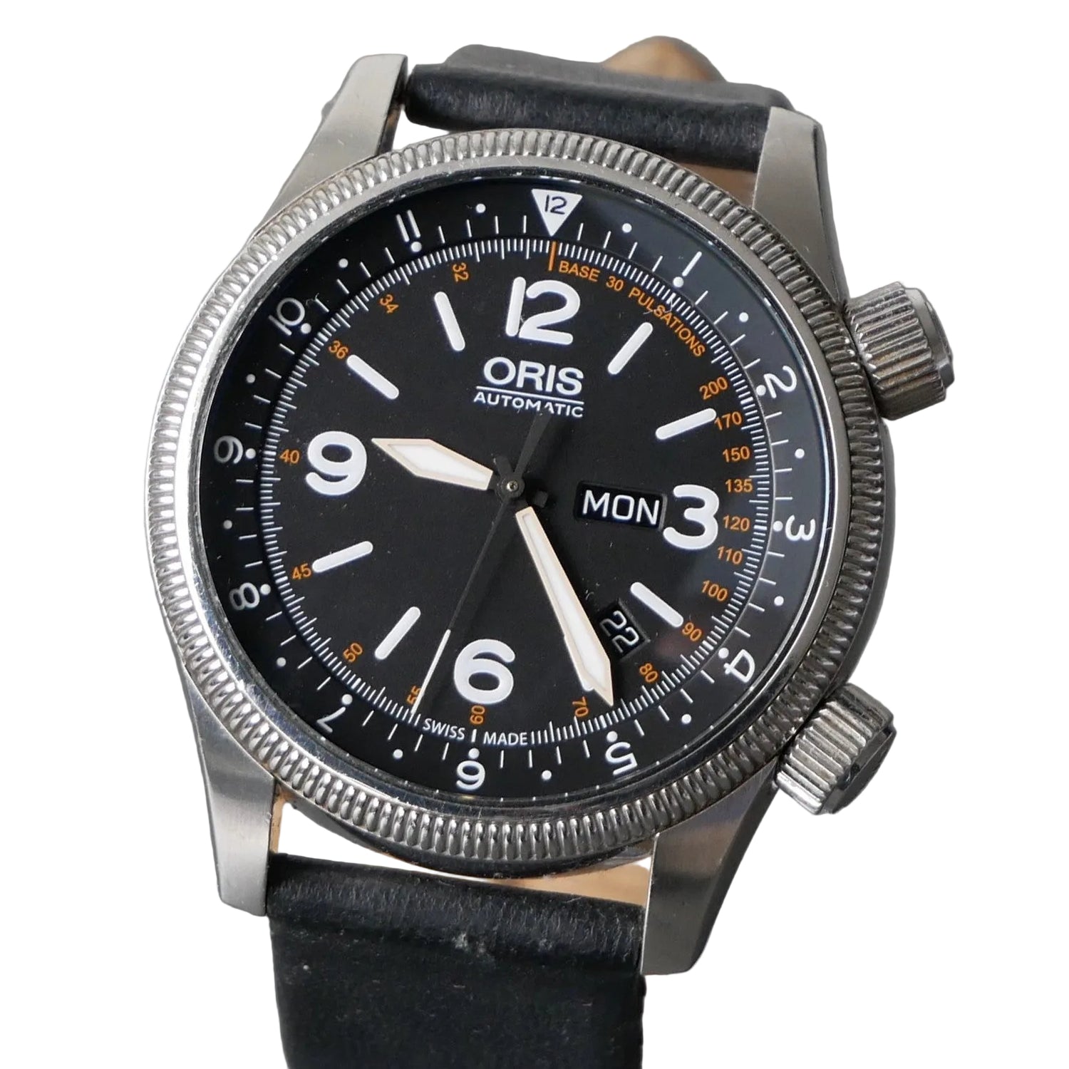 An Oris Automatic watch with a black dial, silver stainless steel case, and a black leather strap, shown close-up against a gray textured background.