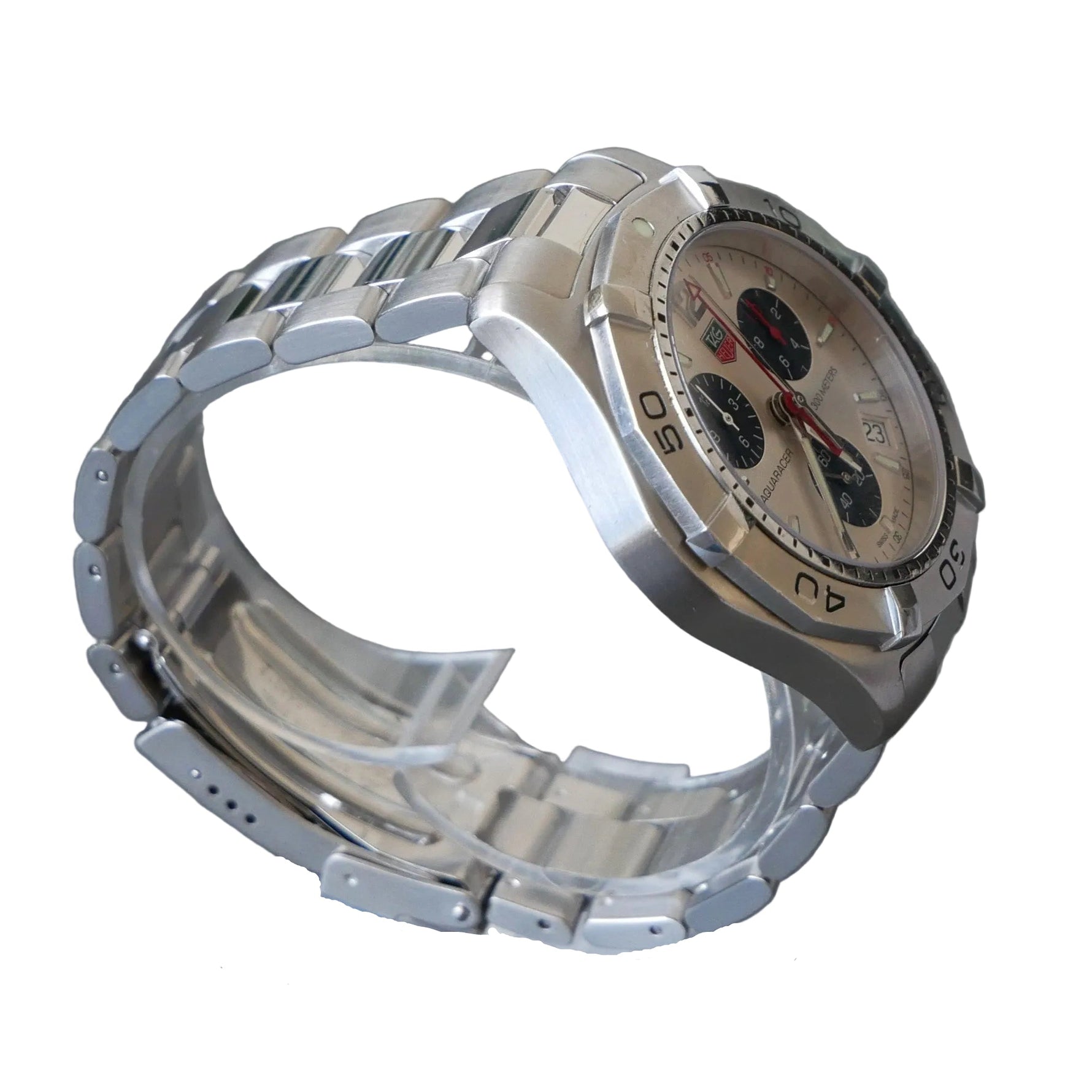 Silver watch on a clear stand against a gray background